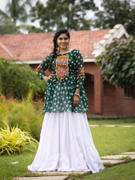 Women Lehenga With Kediya Top for Navratri Celebrate the joy of Navratri with our vibrant and traditional Women’s Lehenga with Kediya Top, specially designed for Garba and Dandiya nights. This colorful ethnic ensemble, featuring bold and festive shades like Rani, Purple, Green, and Yellow, is a true reflection of the season’s spirit and cultural heritage. At EthnicSuits.in, we bring you trendy yet traditional Navratri outfits that combine comfort with eye-catching design. This lehenga with kediya top is a must-have addition to your festive wardrobe! Colorful and Captivating Design This festive Navratri set includes: Lehenga (Skirt): Flowy and flared, designed with multi-color panels in shades of rani pink, purple, green, and yellow, creating a lively and playful look. Accented with traditional prints, embroidery, or mirror work (if applicable), it moves beautifully with every twirl. Kediya Top (Short Frock Style Top): Featuring a peplum-style flare with embroidered detailing or mirror accents, designed in a coordinating color palette. The Kediya top is inspired by Gujarati folk fashion, adding an authentic Garba vibe. Dupatta (Optional): A matching or contrast dupatta may be included with lace borders or tassels to complete the look. Ideal for Garba, Dandiya, and Navratri Nights Designed to reflect traditional Gujarati aesthetics with a modern twist, this lehenga-kediya set is perfect for dance performances, Navratri events, and festive celebrations. The combination of vibrant colors like rani and yellow with the richness of purple and green makes this outfit festive, joyful, and camera-ready. Comfortable Fit & Dance-Friendly Made with soft, breathable fabric, this set ensures all-night comfort during Garba or Dandiya raas. The lehenga’s flared cut allows for easy movement, while the kediya top offers a flattering silhouette that suits all body types. Why Buy from EthnicSuits.in? ✔ Traditional Navratri wear with a modern twist ✔ Festive colors: Rani, Purple, Green & Yellow ✔ Comfortable and lightweight materials ✔ Fast delivery and secure checkout ✔ Trusted brand for ethnic & festive fashion Get ready to dazzle this Navratri in our multi-color Lehenga with Kediya Top – a perfect fusion of style, tradition, and dance-friendly design. Order now from EthnicSuits.in and make every twirl count!
